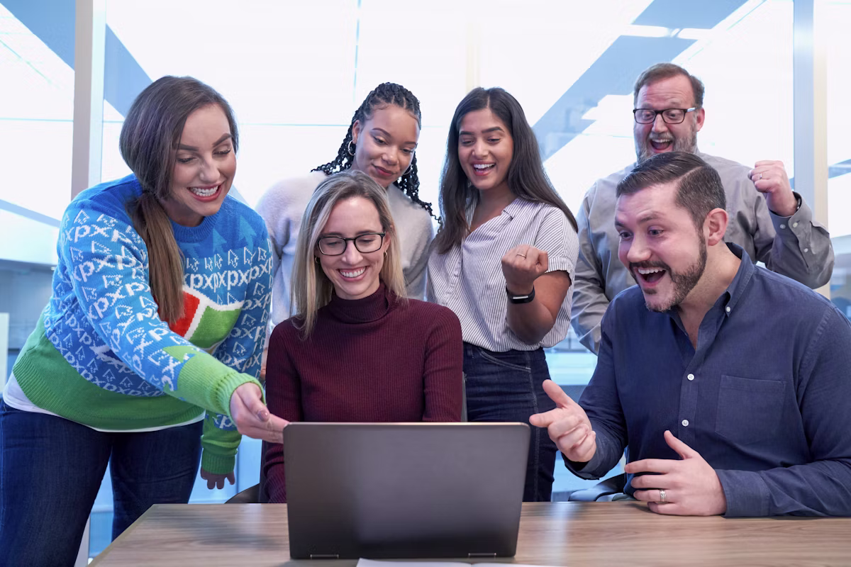 Team collaborating around a laptop reviewing department routing
